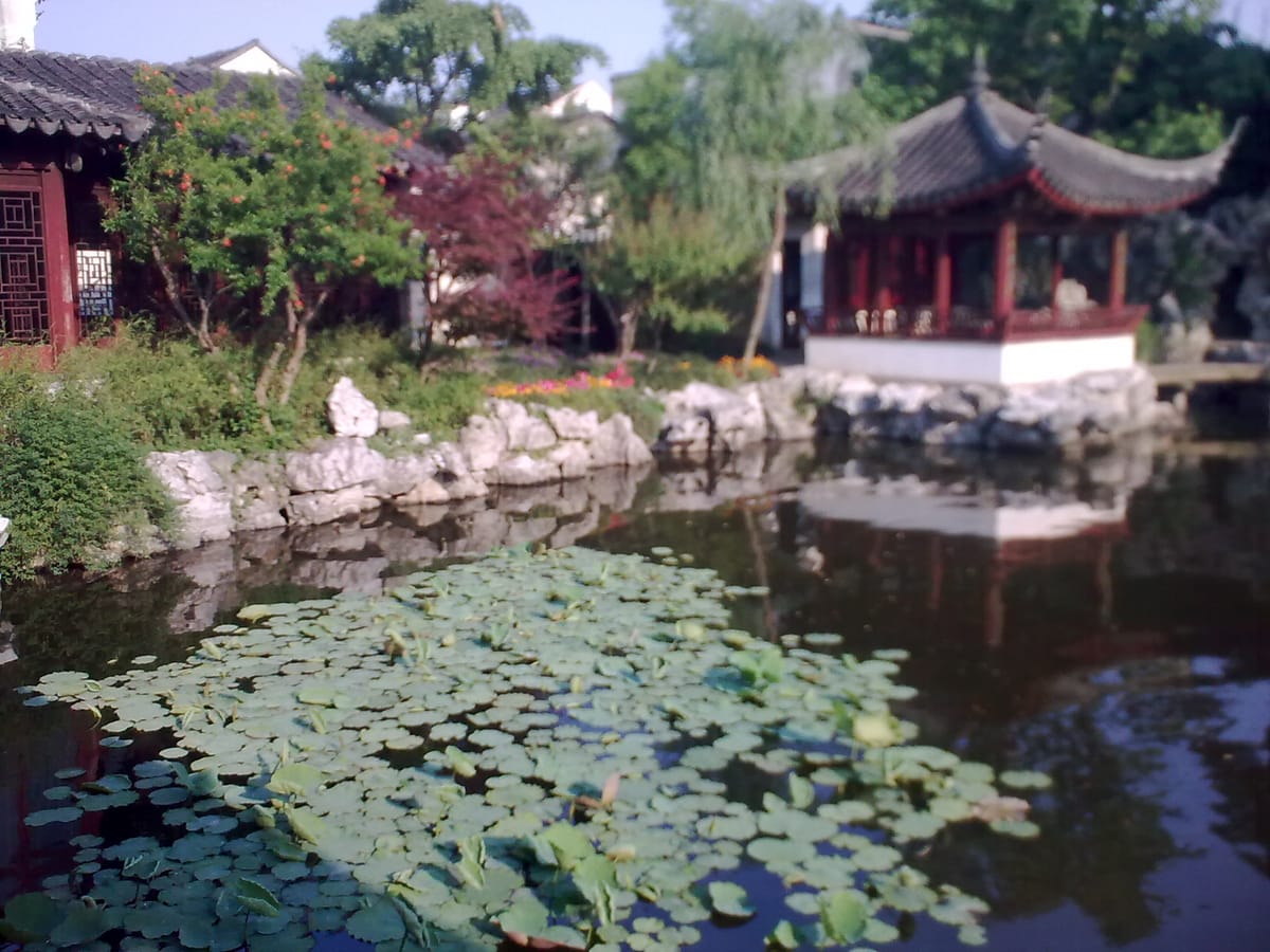 Lotus pond and a classical pavilion at the Garden of Cultivation in Suzhou