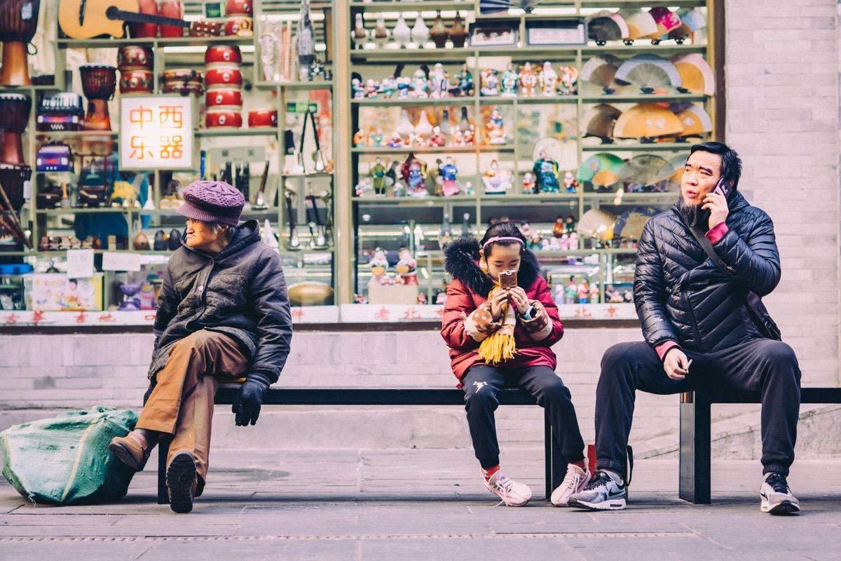 People checking their phones on a street in China