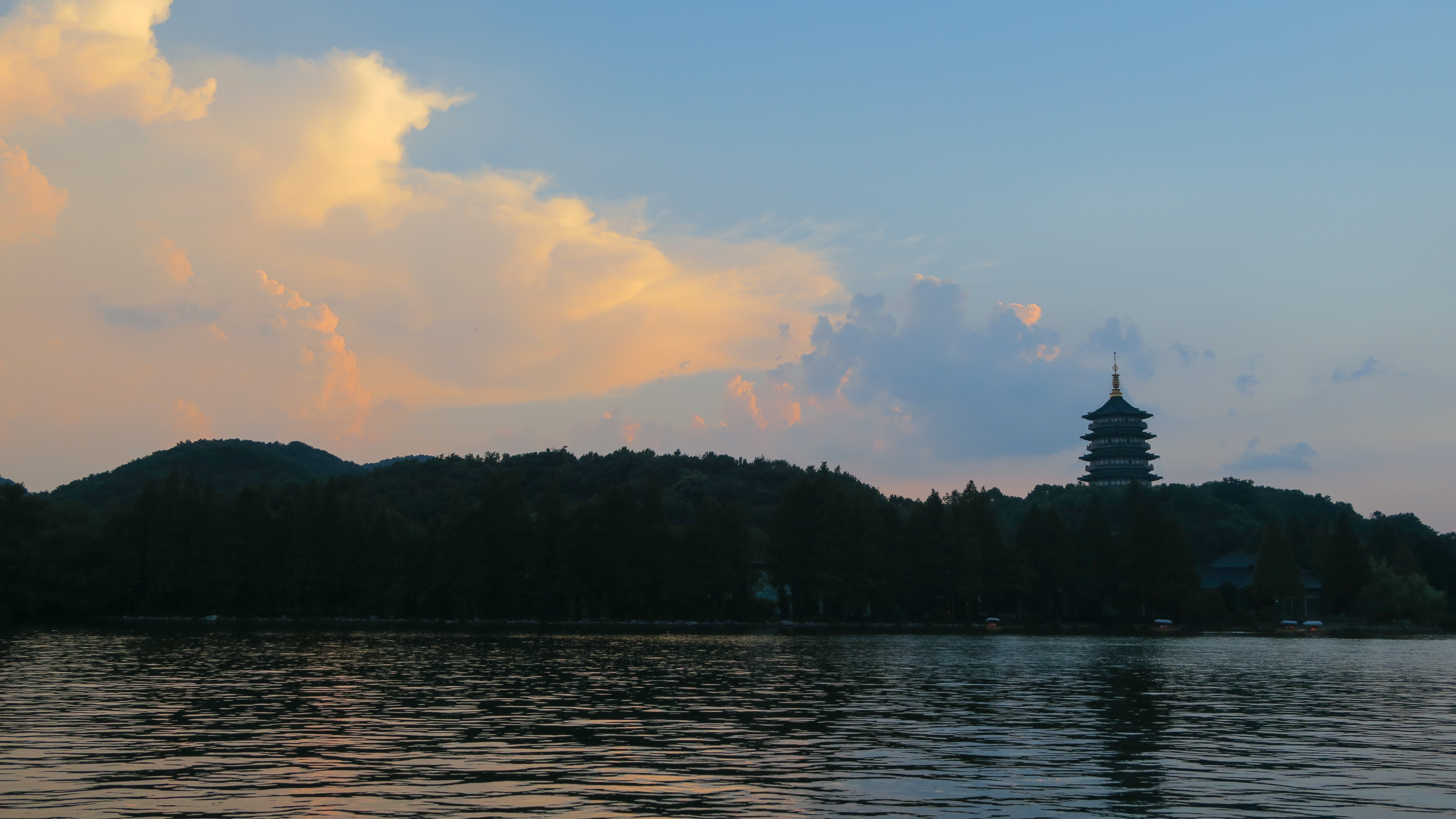 Leifeng Pagoda silhouetted across West Lake at dusk
