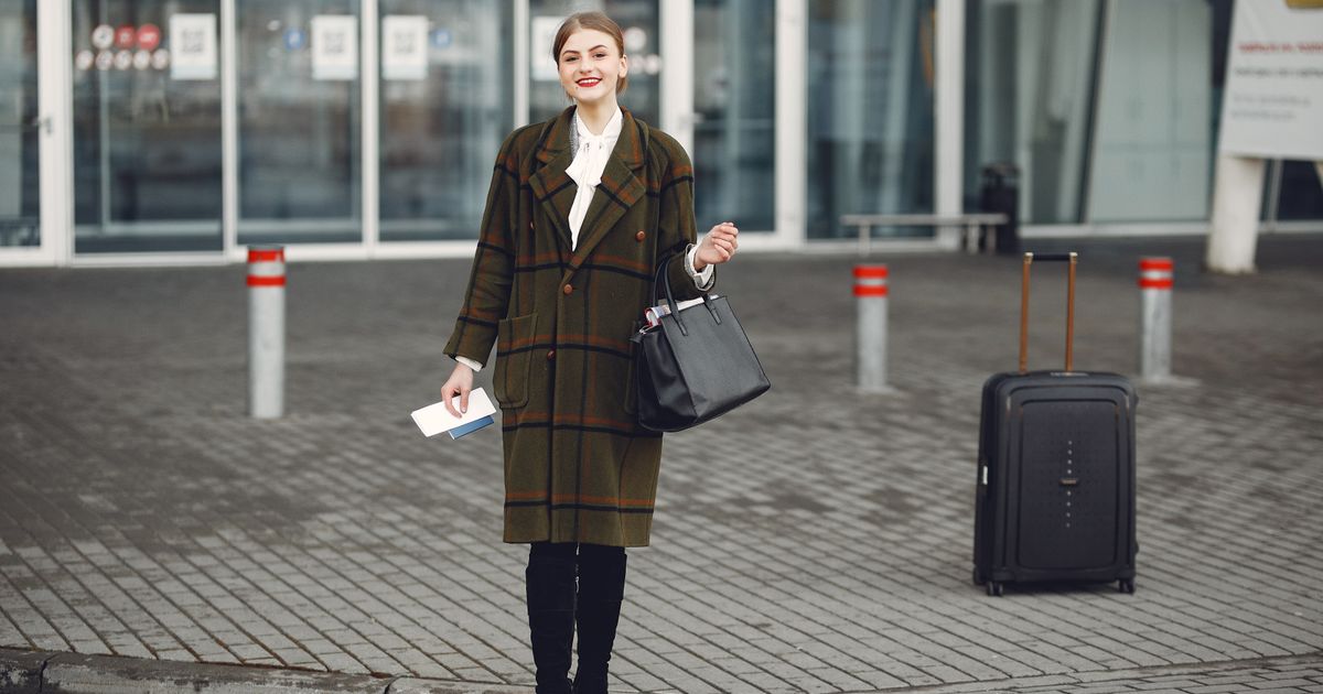 Traveler arriving at the airport departures area with passport and boarding pass