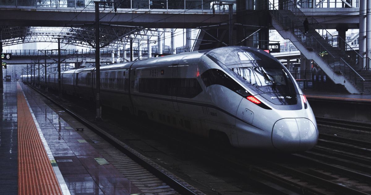 Sleek silver Chinese high-speed train waiting at a covered station platform