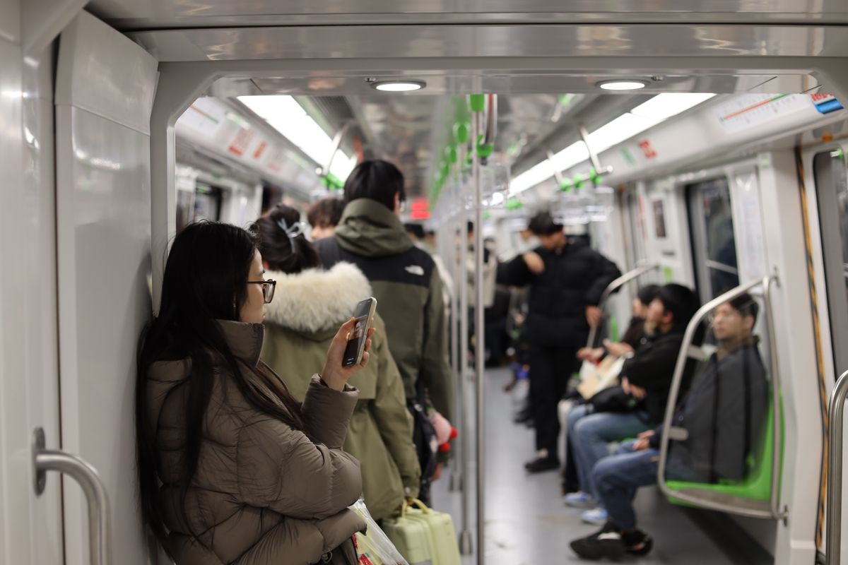 Commuters using their phones aboard a subway train in Nanjing, China