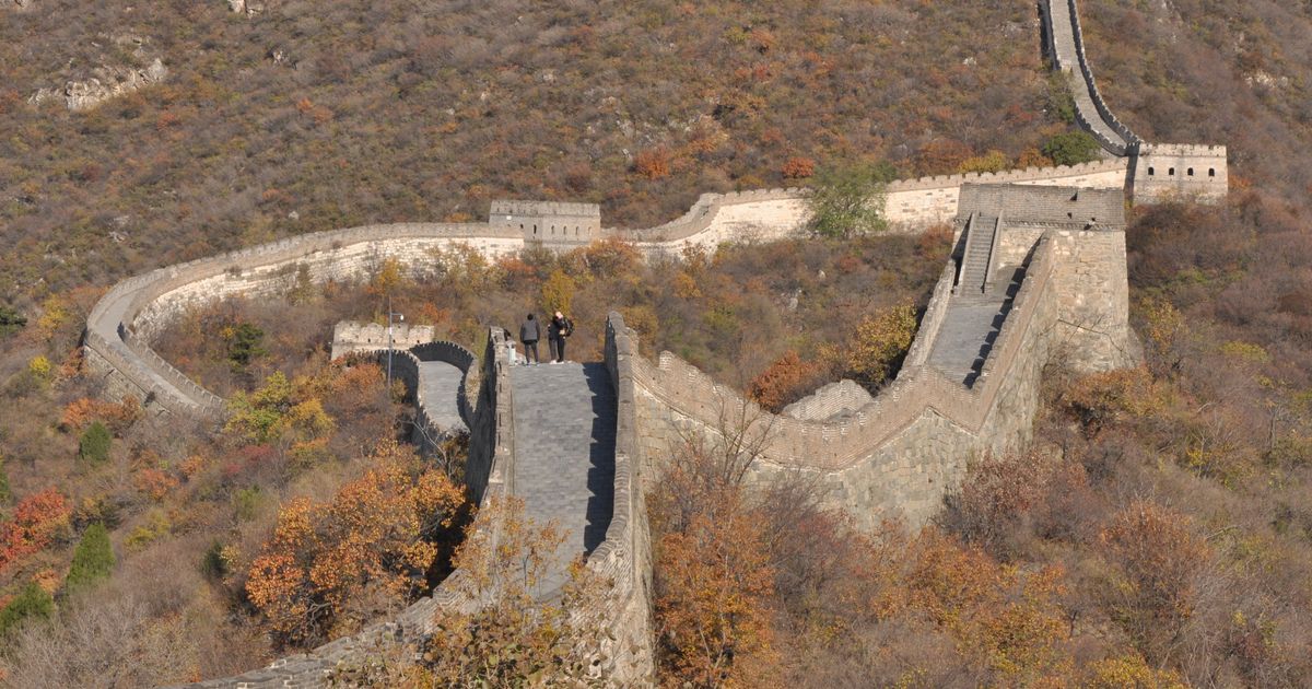 Autumn foliage along the Mutianyu Great Wall with visitors on the ramparts