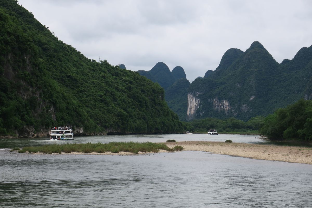 Cruise boats gliding on the Li River below the karst peaks
