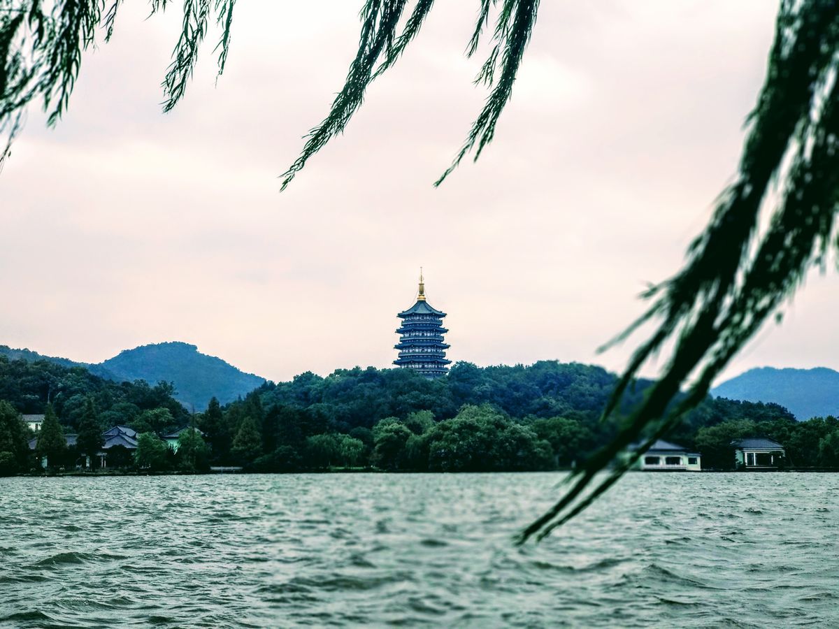 Leifeng Pagoda framed by willow branches over West Lake