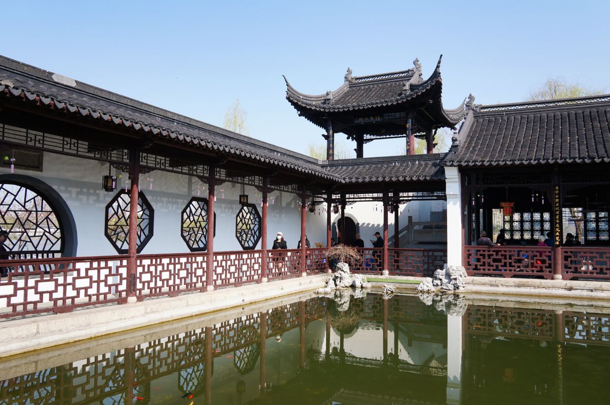 A classical garden pavilion reflected in a pond at Yu Garden