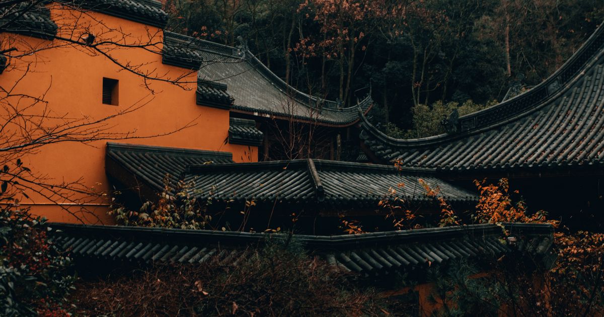 Lingyin Temple's tiered roofs and ochre walls amid forested hills near Hangzhou