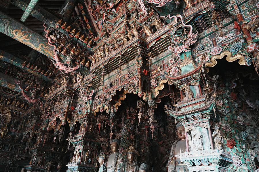 Ornately painted and carved temple hall interior at Lingyin