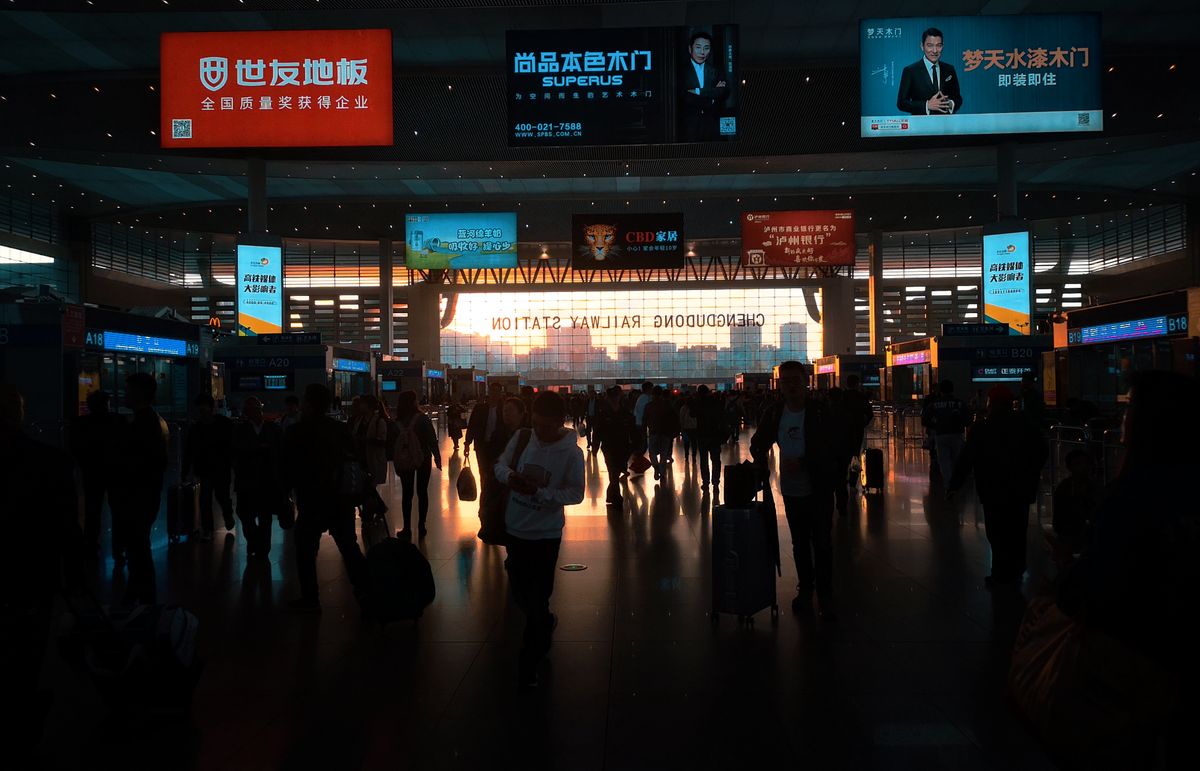 Travelers inside a busy China railway station hall