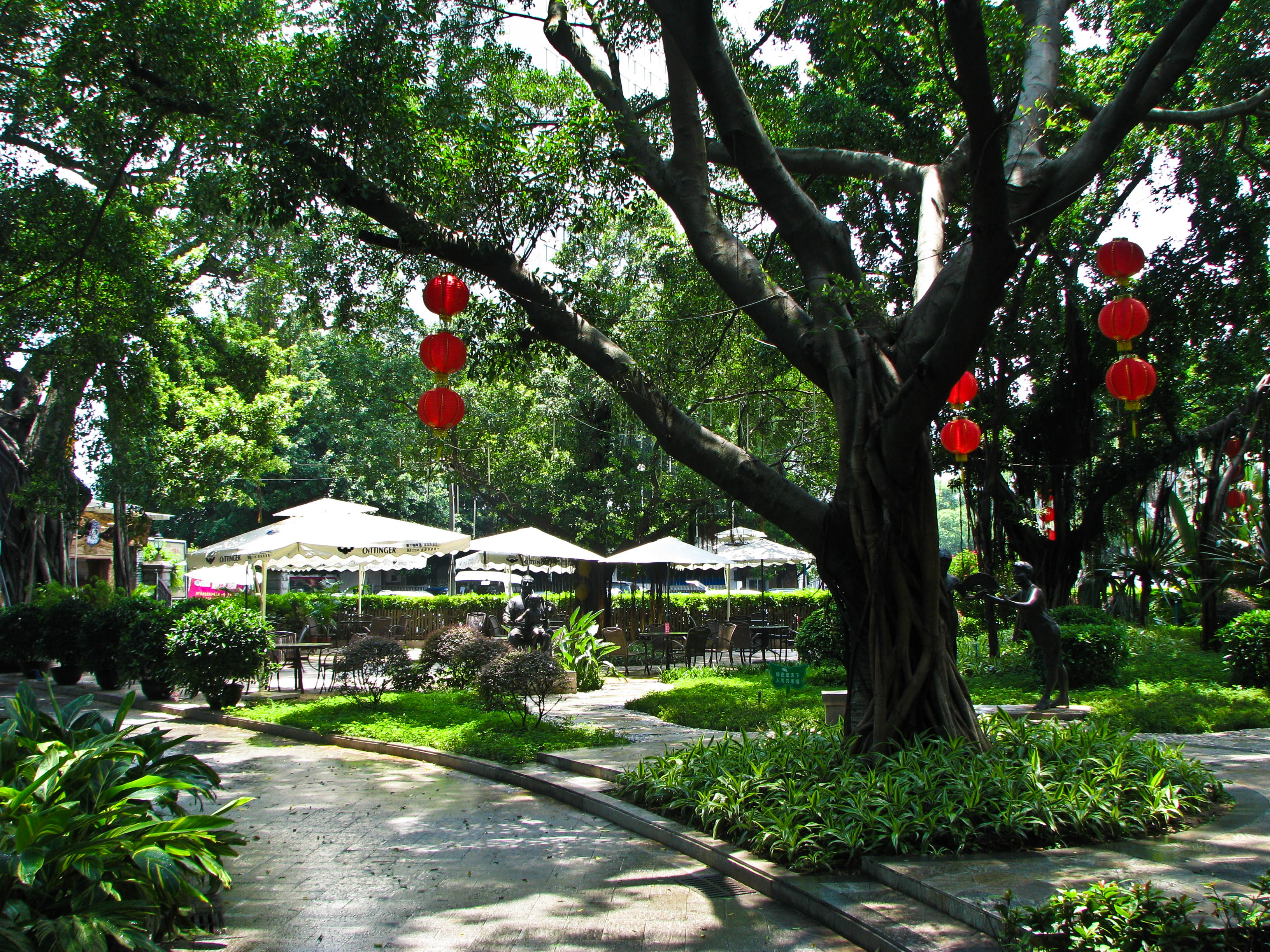 A tree-lined garden boulevard with sculptures on Shamian Island