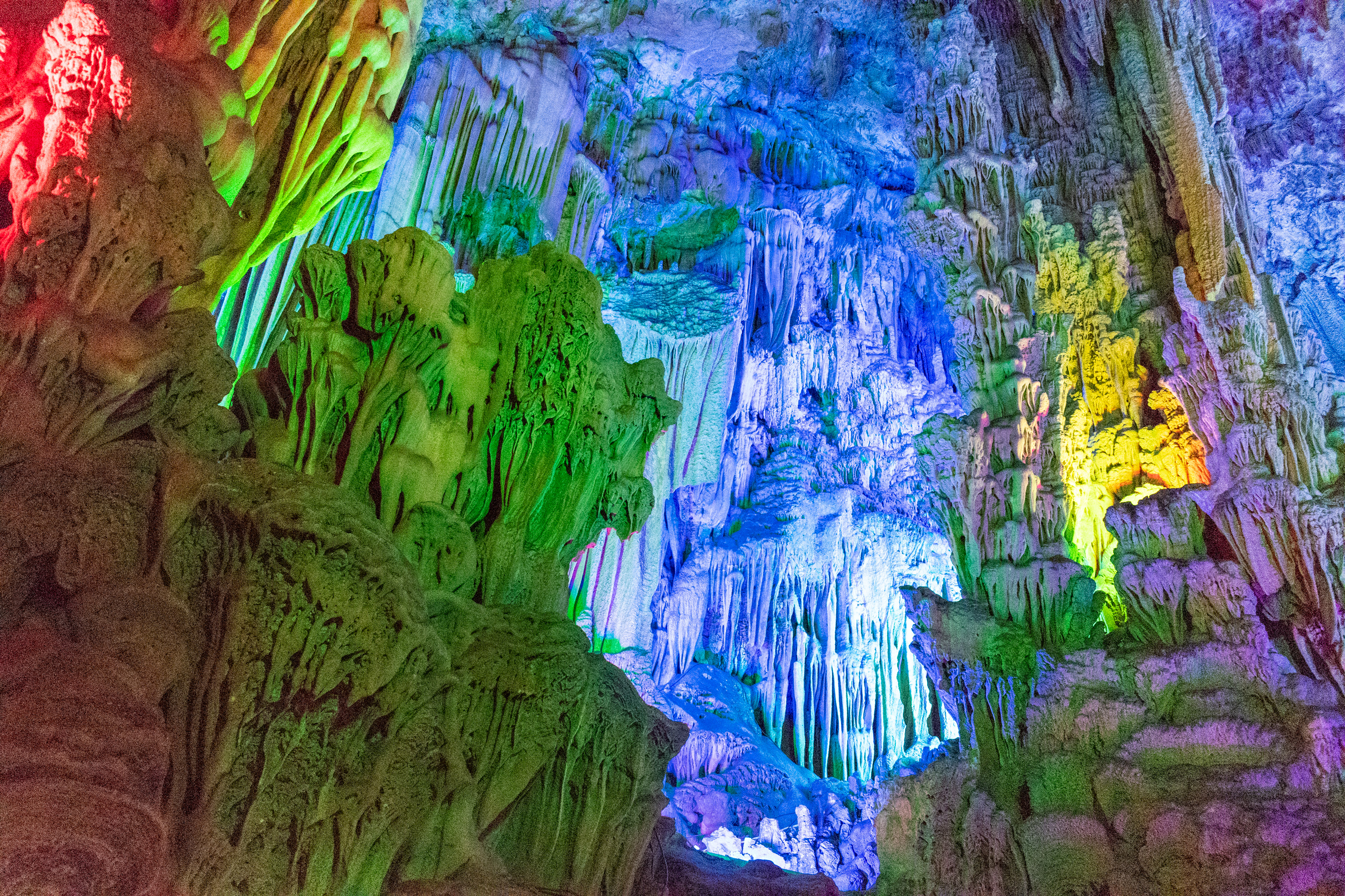 Rainbow-lit stalactites inside Reed Flute Cave