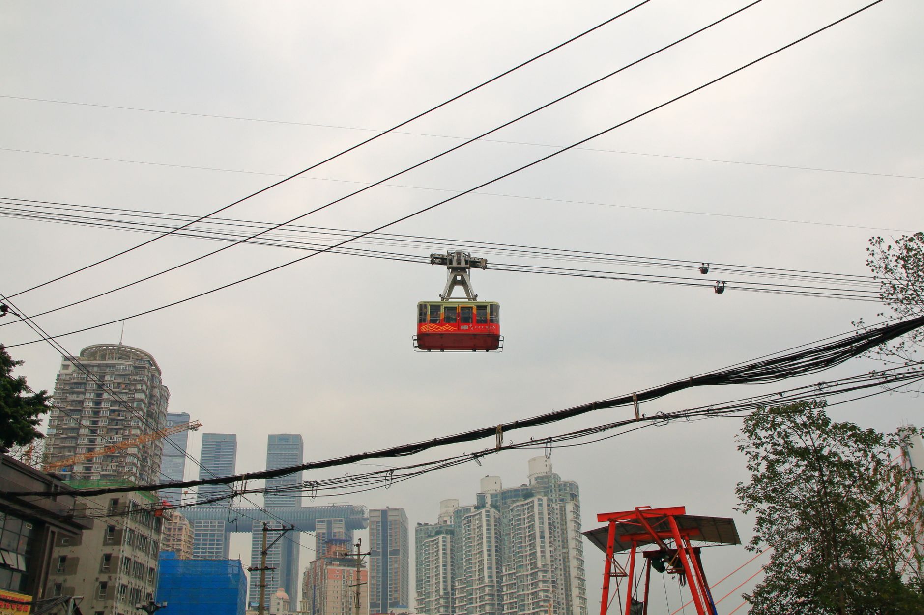 Red cableway gondola above the river with mountains behind