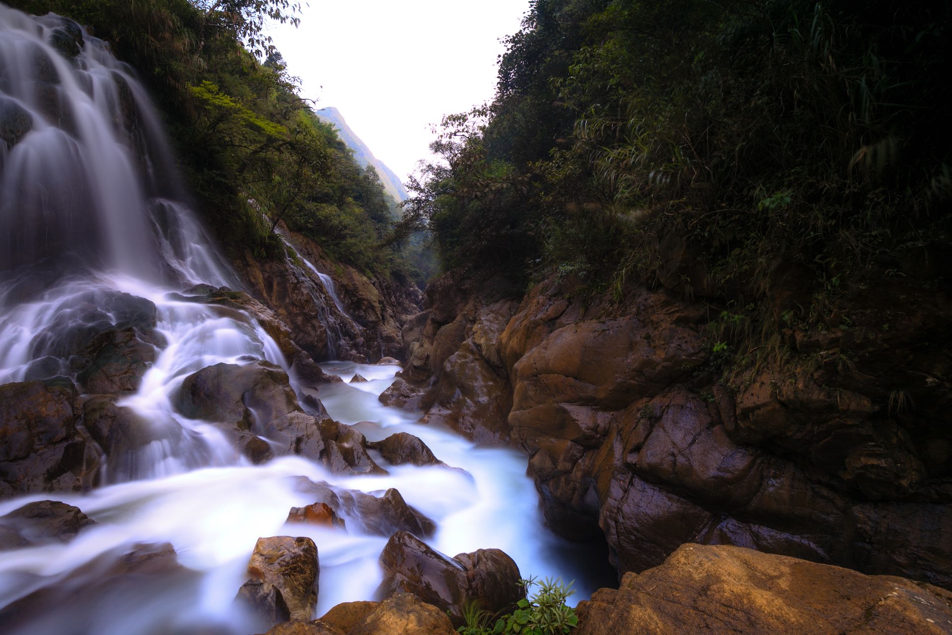 Waterfall cascading over rocks into a clear pool at Emerald Valley