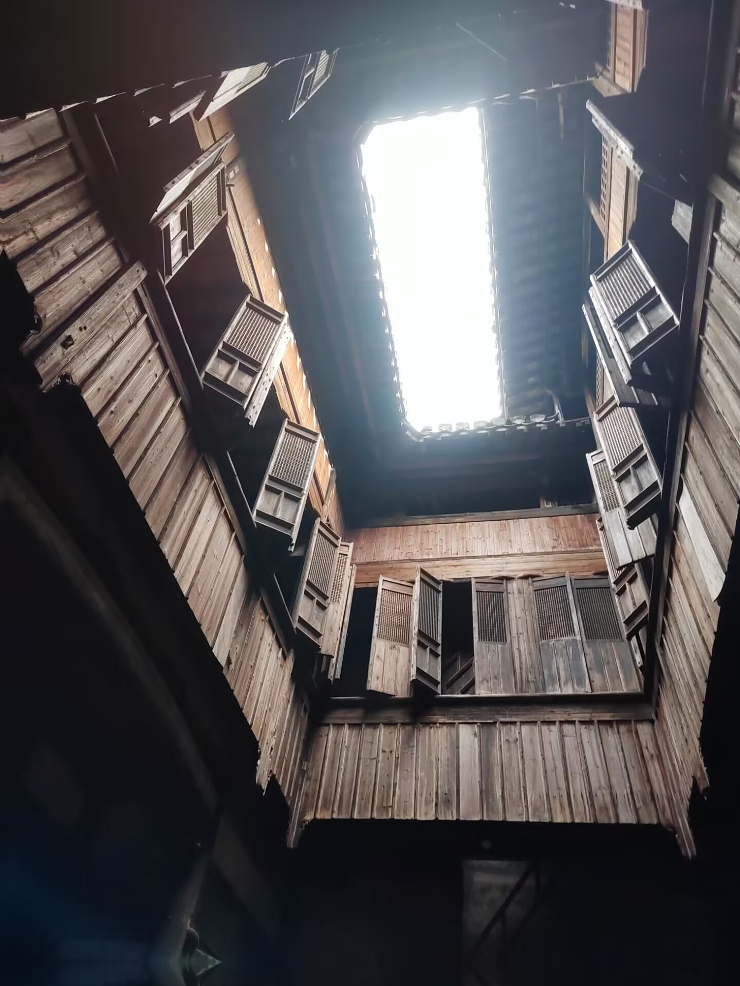 Looking up at a wooden sky-well courtyard in a Chengkan house