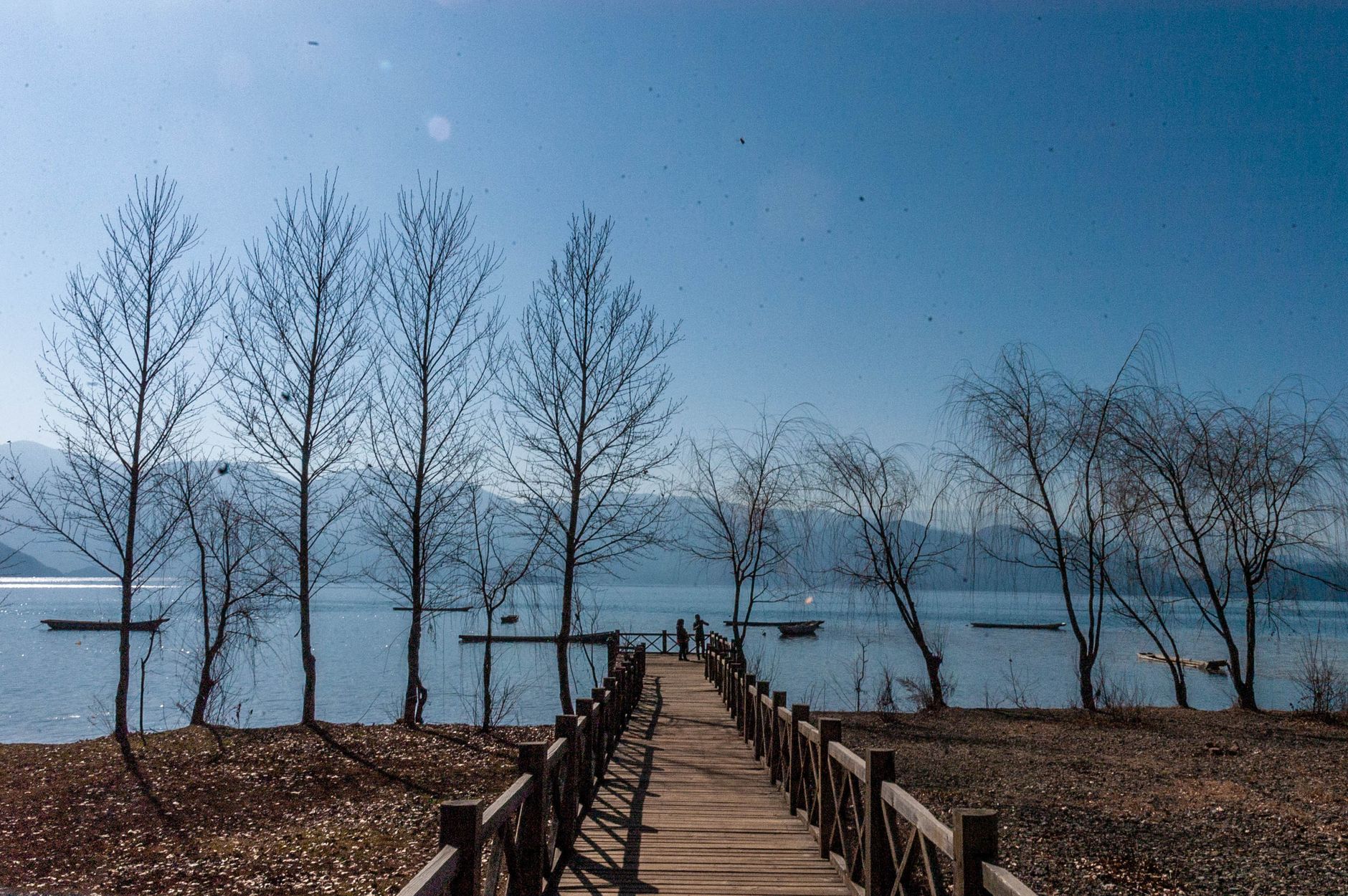 Calm shoreline and dock at Lugu Lake