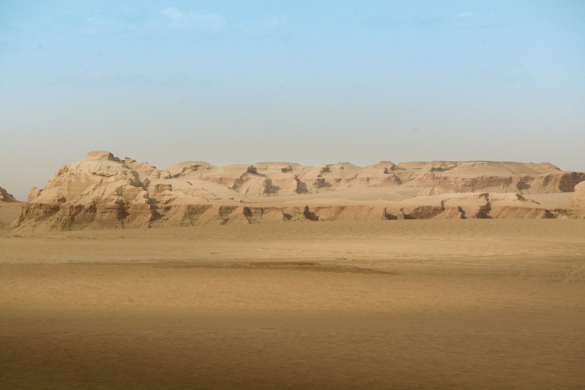 Eroded clay ridges stretching across the desert at sunset