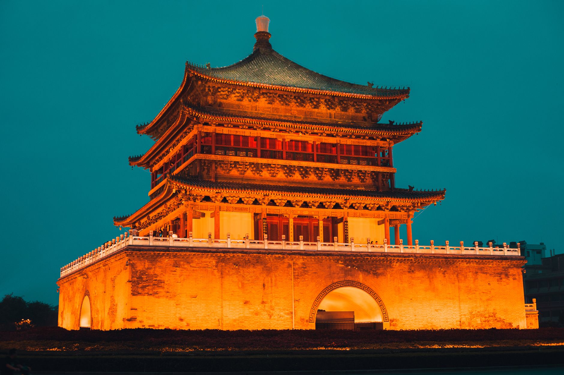 The Bell Tower glowing under floodlights at night above the central roundabout