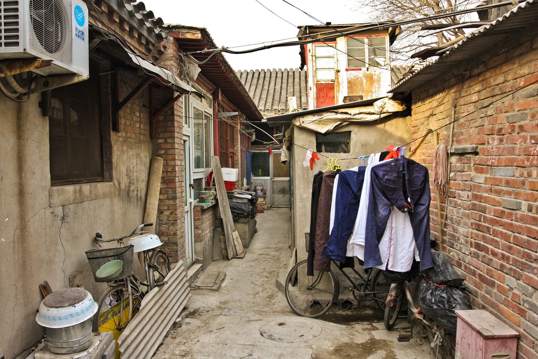 A quiet residential side alley off Nanluoguxiang with bicycles and laundry