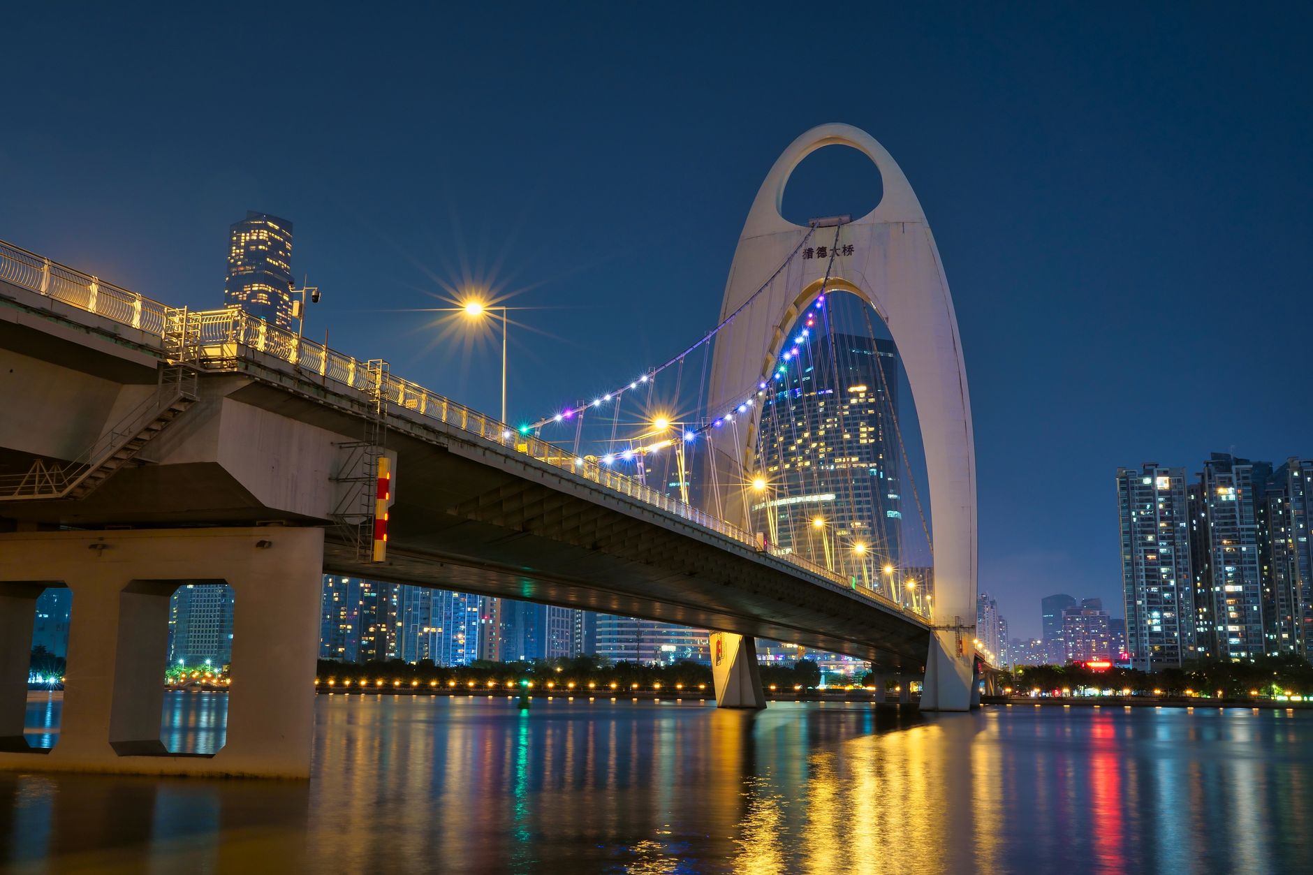 Liede Bridge arching over the Pearl River, lit in colour against the Guangzhou night skyline