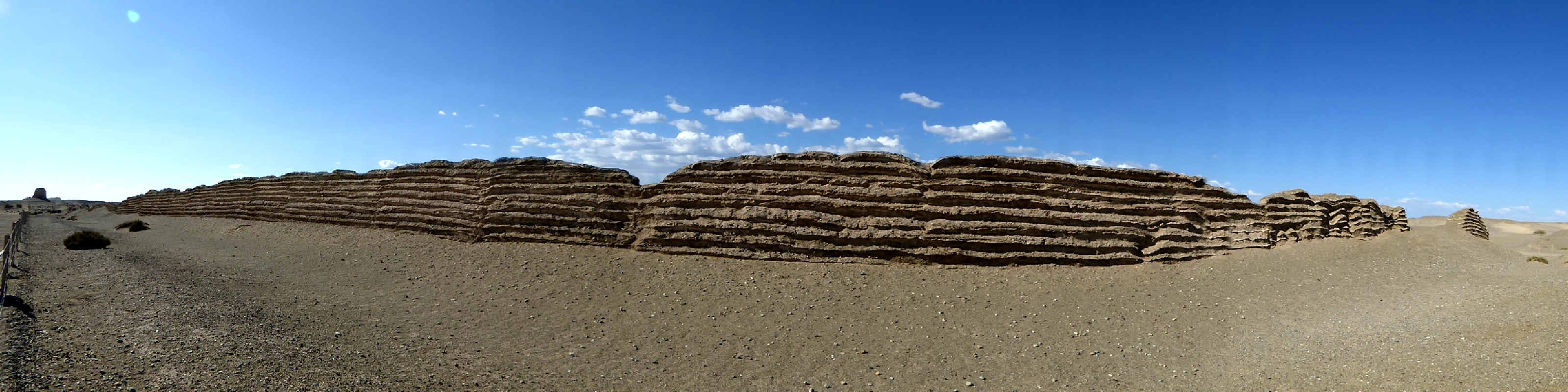 Layered rammed-earth and reed courses of the Han Great Wall against the Gobi sky