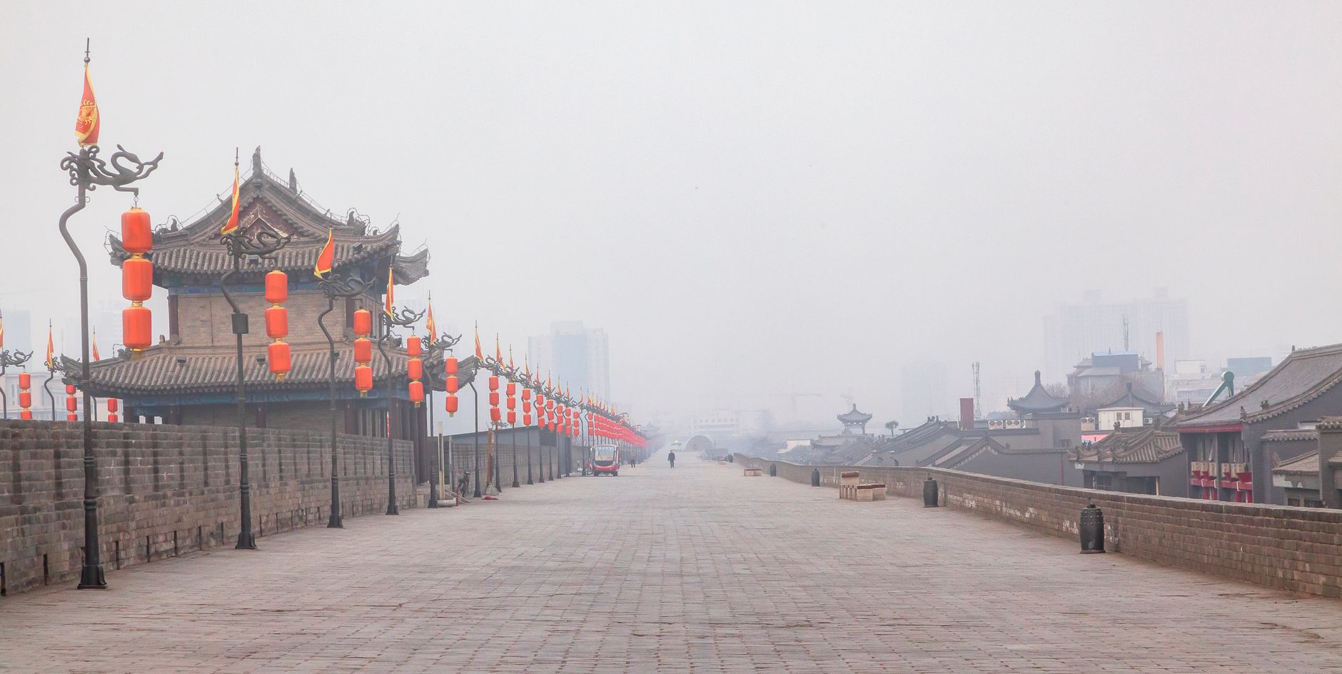 Cyclists and red lanterns on top of the broad Xi'an City Wall