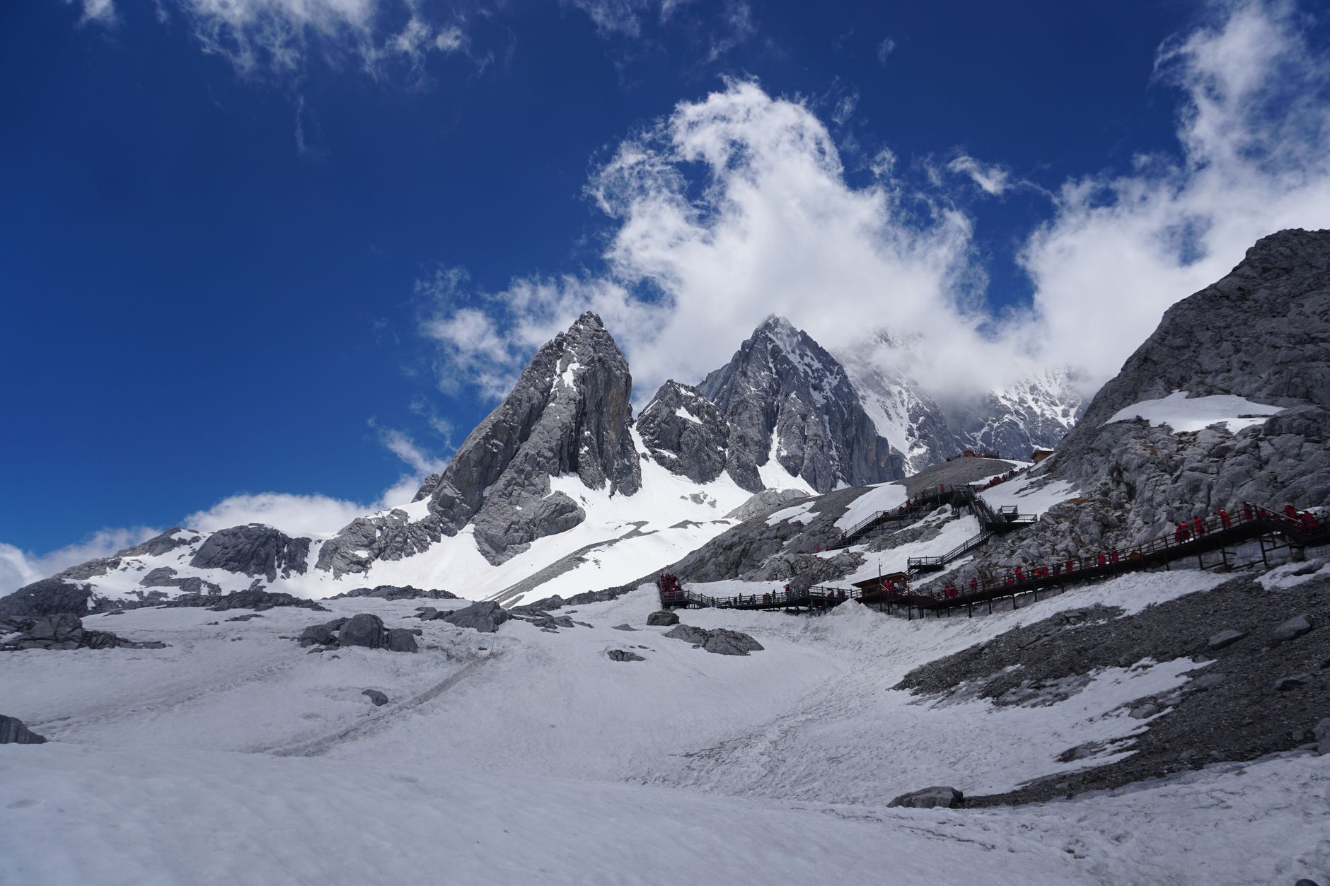 The jagged snow peaks of Jade Dragon Snow Mountain above the glacier park boardwalk