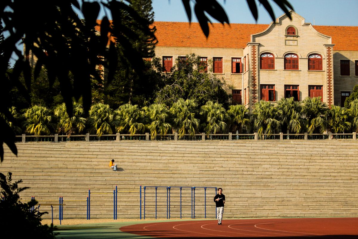 Students on the running track below the historic red-brick halls of Xiamen University