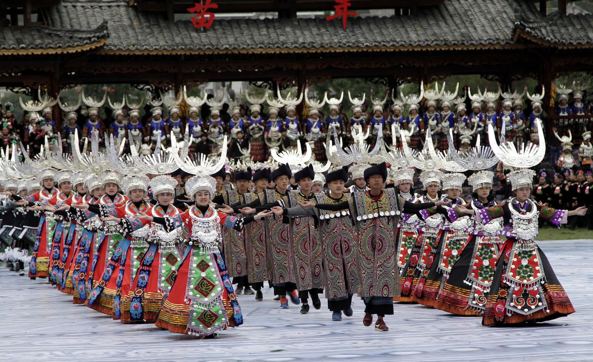 Minority dancers in silver headdresses performing