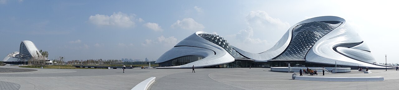 Panorama of the Harbin Grand Theatre's white undulating shell beside the wetland