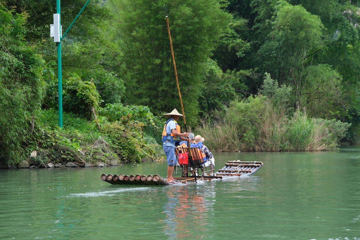 Bamboo rafts drifting on the Yulong River below karst peaks
