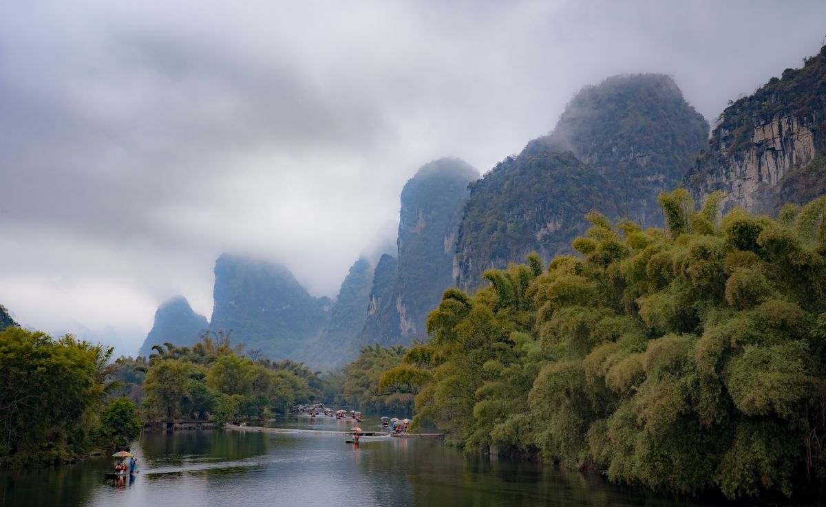 Fisherman and bamboo raft on the Li River at dusk